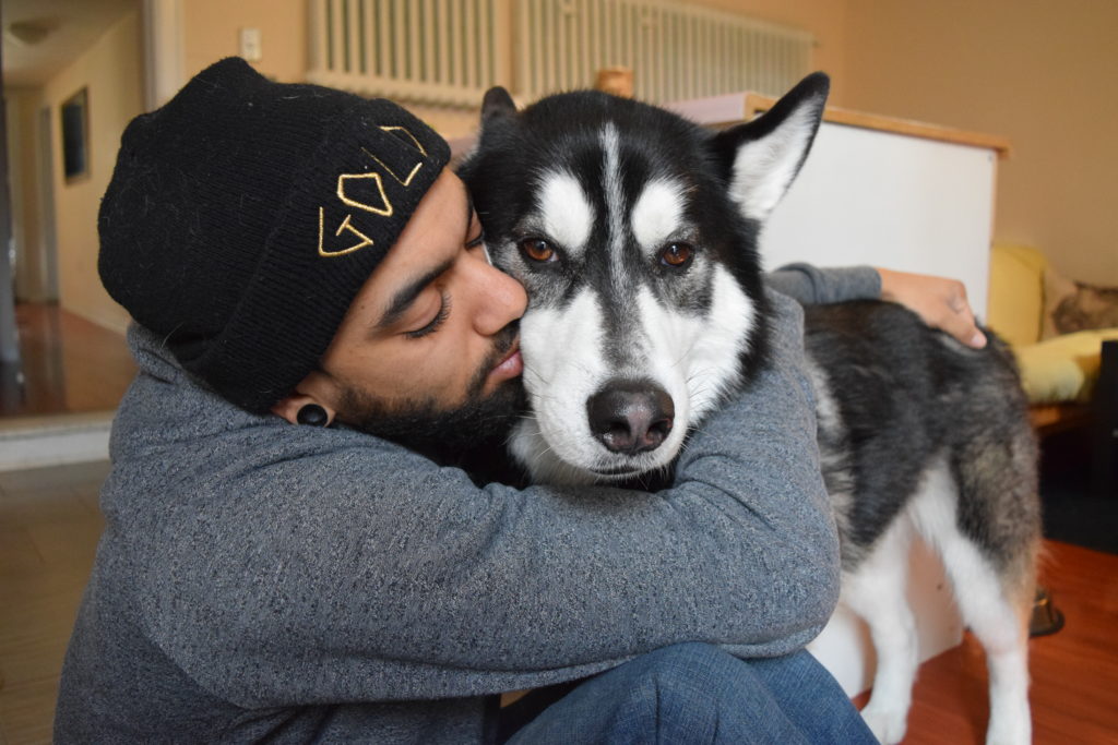 Man hugging dog on the floor