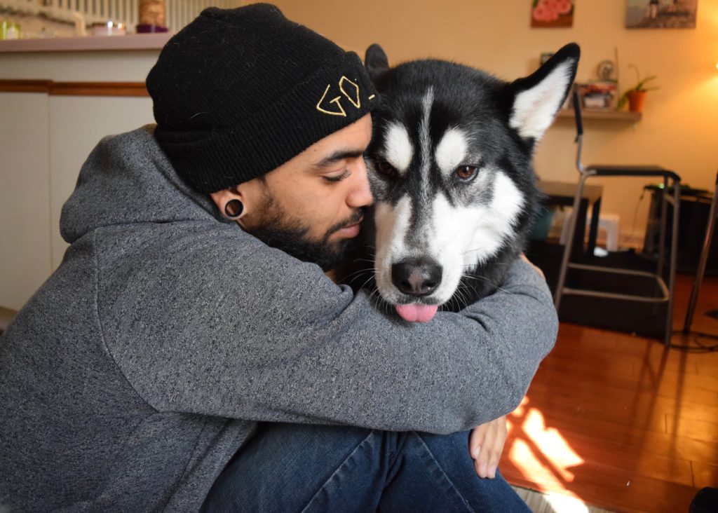 Man hugging dog on the floor