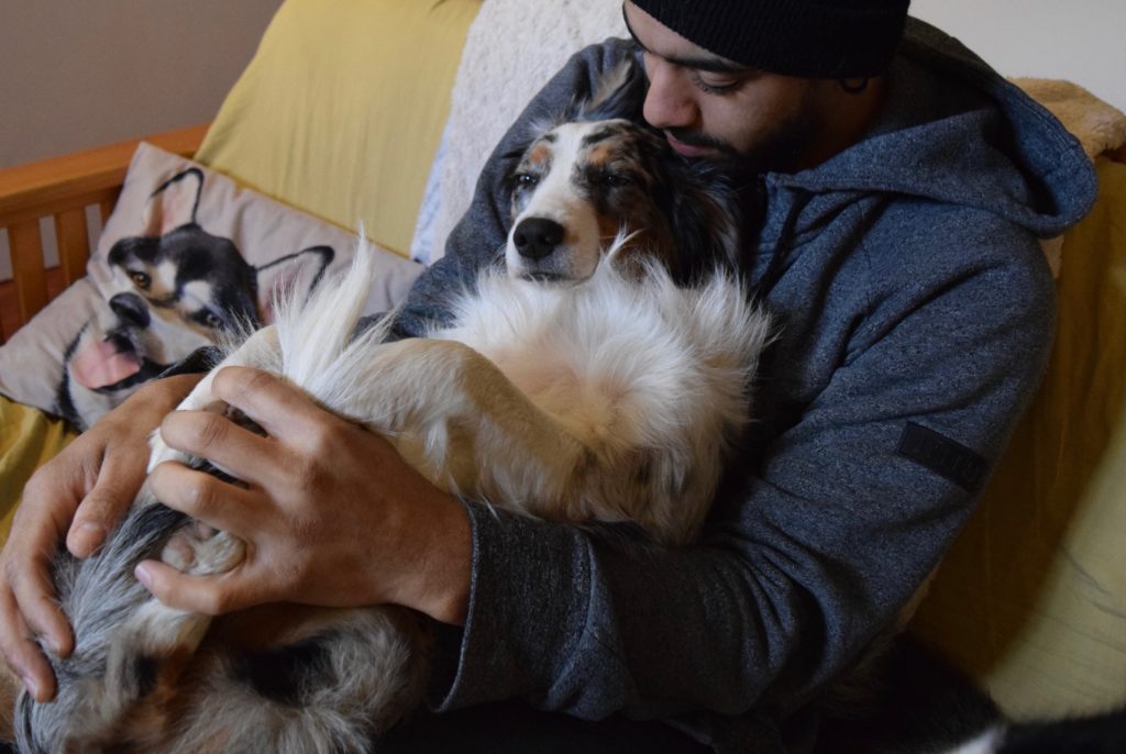 Man hugging dog on the couch