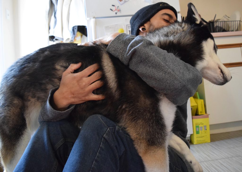 Man hugging dog on the floor